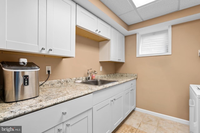 6317 Taylor Rd, Riverdale, MD 20737 - kitchen with washer / dryer, white cabinets, and light stone countertops