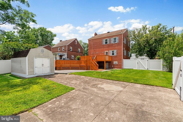 6317 Taylor Rd, Riverdale, MD 20737 - back of house with a gate, a deck, a fenced backyard, a storage unit, and a patio area