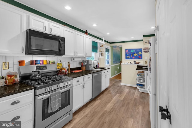 525 Center Dr, Severna Park, MD 21146 - kitchen with stainless steel appliances, white cabinetry, light wood-style floors, decorative backsplash, and recessed lighting