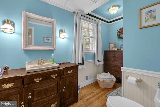 525 Center Dr, Severna Park, MD 21146 - bathroom with vanity, wood finished floors, crown molding, and wainscoting