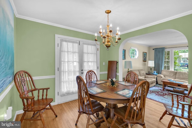 525 Center Dr, Severna Park, MD 21146 - dining room with arched walkways, light wood-type flooring, crown molding, and a chandelier