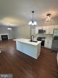 5920 Plata St, Clinton, MD 20735 - kitchen with stainless steel appliances, a chandelier, white cabinets, light countertops, and dark wood-style flooring