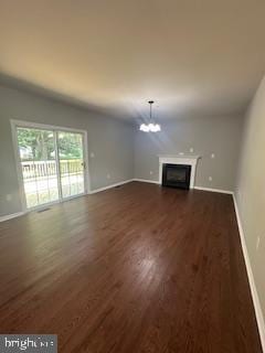 5920 Plata St, Clinton, MD 20735 - unfurnished living room with dark wood-type flooring, a chandelier, and a fireplace
