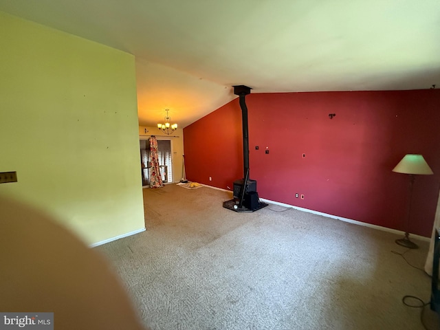 187 Merion Rd, Dover, DE 19904 - unfurnished living room with a wood stove, a chandelier, carpet floors, lofted ceiling, and baseboards