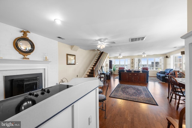3685 1st Ave, Edgewater, MD 21037 - living room with ceiling fan, dark wood-type flooring, a fireplace, and stairway