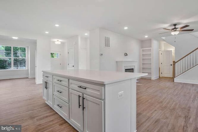 22640 Excel Ct, Lexington Park, MD 20653 - kitchen with ceiling fan, open floor plan, light wood-style floors, a kitchen island, and light countertops