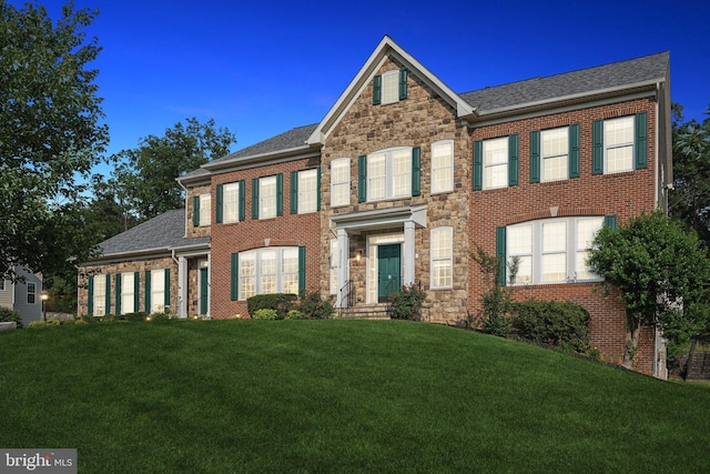 21550 Wild Timber Ct, Broadlands, VA 20148 - colonial home featuring a front lawn, stone siding, a shingled roof, and brick siding