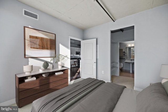 2125 14th St NW Unit 618, Washington, DC 20009 - bedroom featuring light carpet, baseboards, and ensuite bathroom