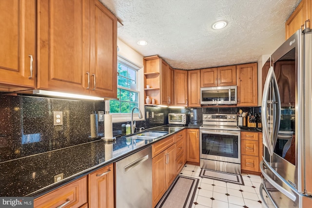 14616 Orangewood St, Silver Spring, MD 20905 - kitchen featuring stainless steel appliances, a sink, open shelves, brown cabinetry, and dark stone counters