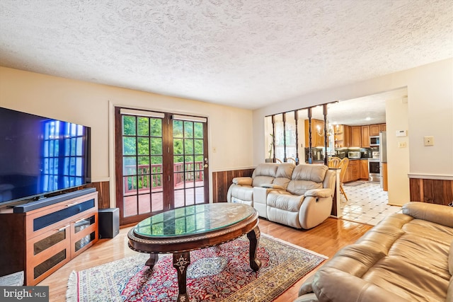 14616 Orangewood St, Silver Spring, MD 20905 - living area with wainscoting, a textured ceiling, light wood-type flooring, and wooden walls