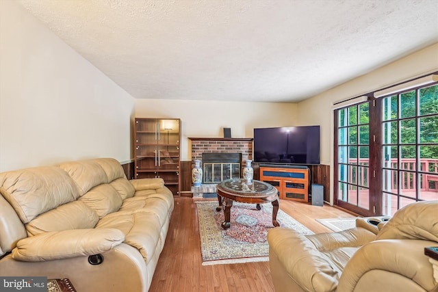 14616 Orangewood St, Silver Spring, MD 20905 - living room with wood finished floors, a textured ceiling, and a brick fireplace