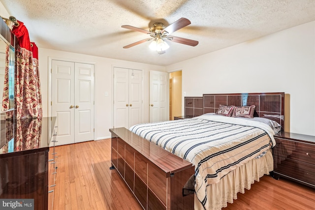 14616 Orangewood St, Silver Spring, MD 20905 - bedroom with light wood finished floors, multiple closets, a textured ceiling, and ceiling fan