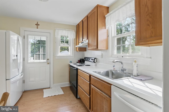 1022 S Beechfield Ave, Baltimore, MD 21229 - kitchen with white appliances, a sink, under cabinet range hood, light countertops, and decorative backsplash