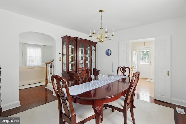 1022 S Beechfield Ave, Baltimore, MD 21229 - dining area with a chandelier, wood finished floors, and arched walkways