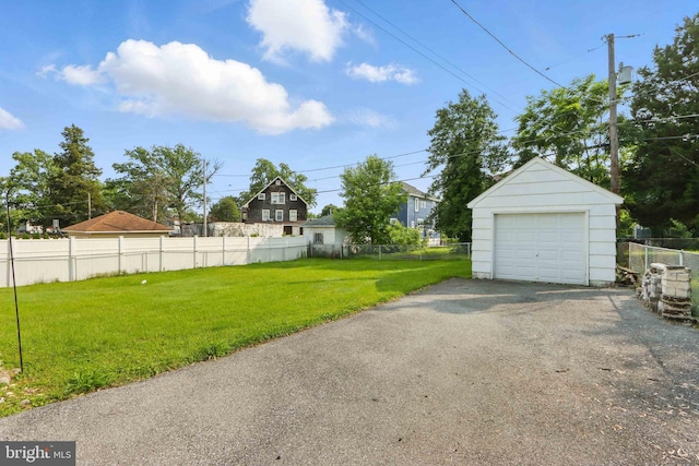 1022 S Beechfield Ave, Baltimore, MD 21229 - view of yard featuring driveway, a detached garage, and an outbuilding
