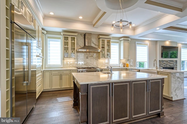 1600 Great Falls St, Mclean, VA 22101 - kitchen with stainless steel appliances, wall chimney exhaust hood, cream cabinets, a center island with sink, and crown molding