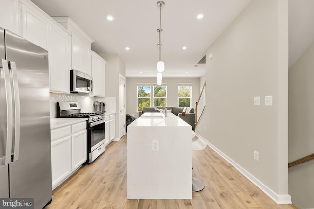 2521 River Terrace Rd, Hyattsville, MD 20782 - kitchen with appliances with stainless steel finishes, white cabinets, a center island with sink, recessed lighting, and light wood finished floors