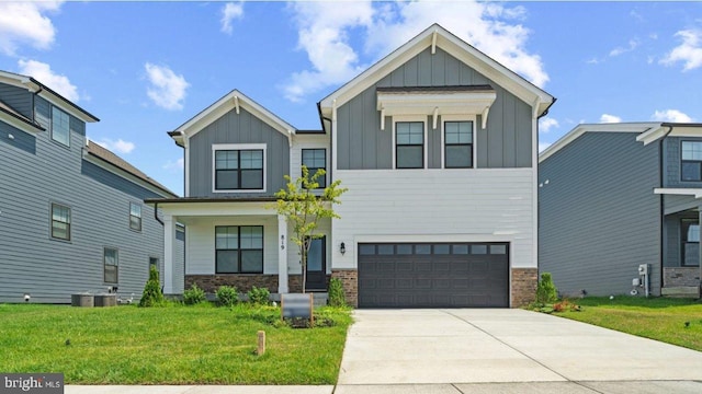 453 Ensemble Way, Frederick, MD 21701 - view of front of home with board and batten siding, an attached garage, a front yard, concrete driveway, and covered porch