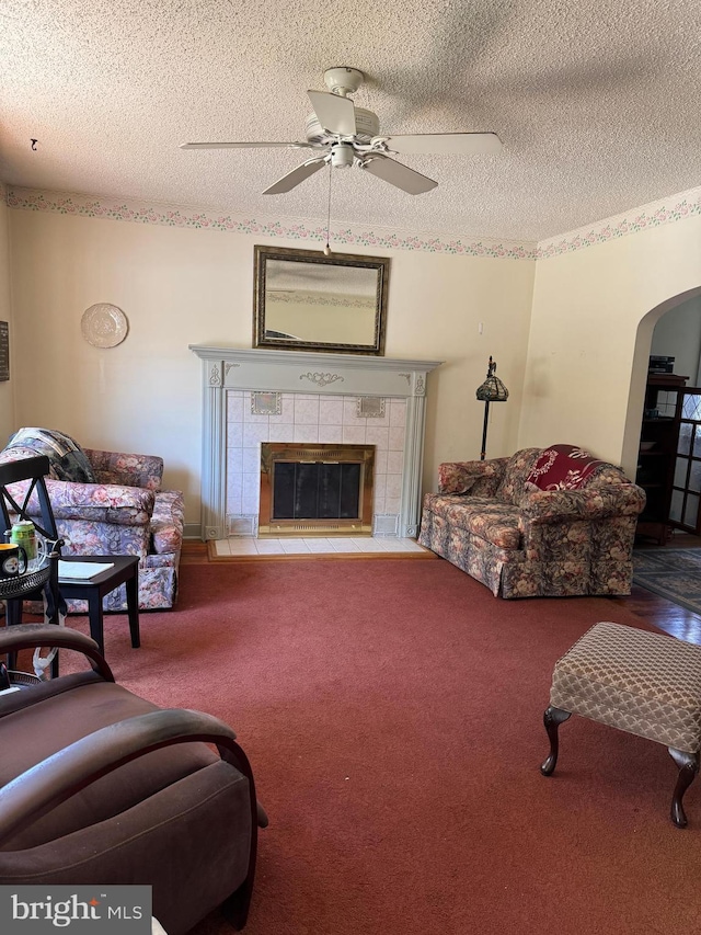 129 Redwood Ave, Trenton, NJ 08619 - living room featuring carpet floors, ceiling fan, arched walkways, a textured ceiling, and a fireplace