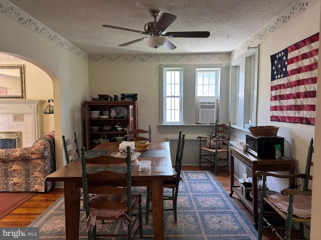 129 Redwood Ave, Trenton, NJ 08619 - dining room featuring wood finished floors, a textured ceiling, arched walkways, cooling unit, and ceiling fan