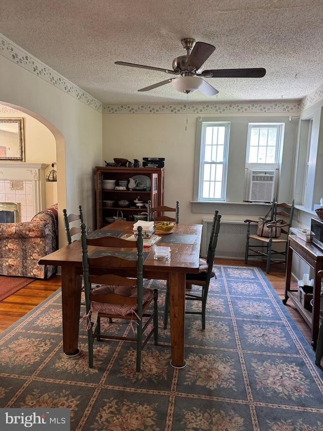 129 Redwood Ave, Trenton, NJ 08619 - dining room featuring wood finished floors, arched walkways, ceiling fan, a textured ceiling, and cooling unit