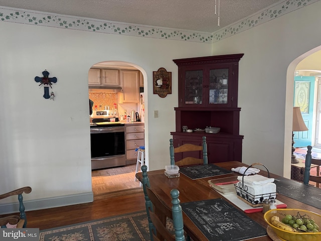 129 Redwood Ave, Trenton, NJ 08619 - dining room featuring arched walkways, wood finished floors, baseboards, and a textured ceiling