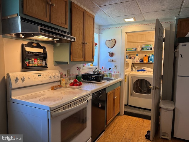 129 Redwood Ave, Trenton, NJ 08619 - kitchen featuring white appliances, washer and clothes dryer, under cabinet range hood, light wood-style floors, and a drop ceiling