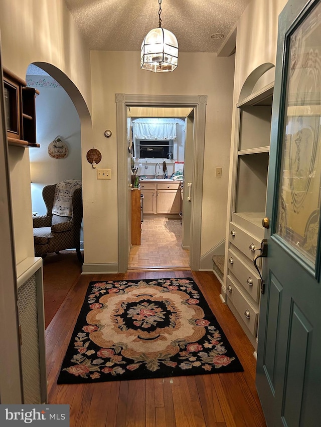 129 Redwood Ave, Trenton, NJ 08619 - entryway featuring light wood finished floors, a textured ceiling, arched walkways, and baseboards