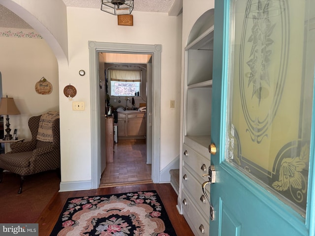 129 Redwood Ave, Trenton, NJ 08619 - entryway featuring dark wood-style flooring, arched walkways, baseboards, and a textured ceiling