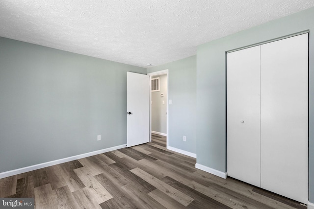 1207 Blithe Ct, Upper Marlboro, MD 20774 - unfurnished bedroom with wood finished floors, a textured ceiling, a closet, and baseboards