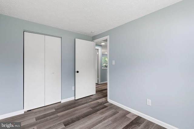 1207 Blithe Ct, Upper Marlboro, MD 20774 - unfurnished bedroom with wood finished floors, a textured ceiling, a closet, and baseboards