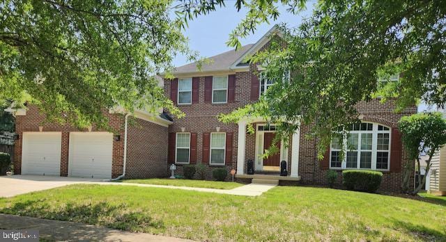 14207 Pollin St, Accokeek, MD 20607 - view of front facade featuring a front lawn, driveway, brick siding, and an attached garage