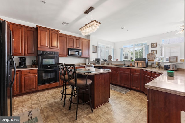 14207 Pollin St, Accokeek, MD 20607 - kitchen featuring black appliances, a kitchen bar, light countertops, and light flooring