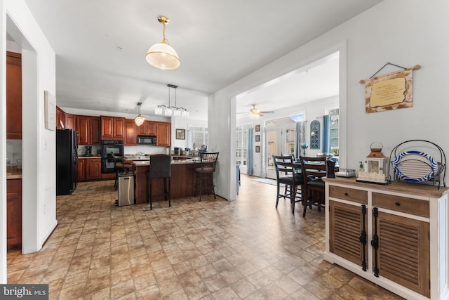 14207 Pollin St, Accokeek, MD 20607 - kitchen featuring black appliances, a peninsula, a breakfast bar, a ceiling fan, and pendant lighting