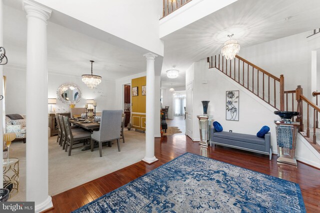 14207 Pollin St, Accokeek, MD 20607 - dining room featuring hardwood / wood-style floors, decorative columns, stairs, and a chandelier