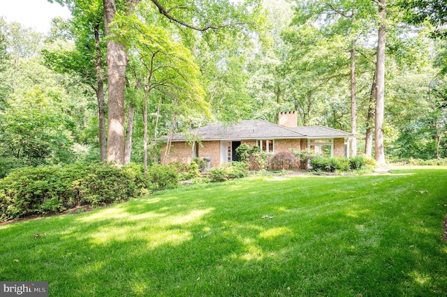 6501 Menlo Rd, Mclean, VA 22101 - ranch-style home with a chimney, a front lawn, brick siding, and a forest view