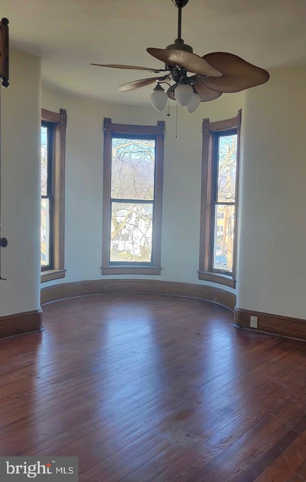89 S Mineral St, Keyser, WV 26726 - spare room with dark wood-type flooring, plenty of natural light, a ceiling fan, and baseboards