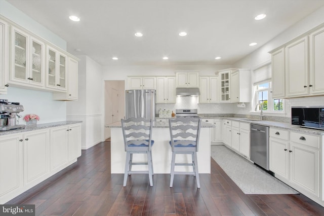3 Rycroft Rd, Mechanicsburg, PA 17050 - kitchen with stainless steel appliances, a sink, under cabinet range hood, light stone counters, and backsplash