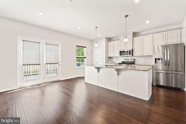 1307 Kohana Dr, Clarksboro, NJ 08020 - kitchen with stainless steel appliances, dark wood-style floors, decorative backsplash, a center island with sink, and light stone counters