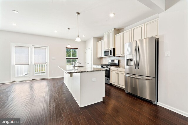 1307 Kohana Dr, Clarksboro, NJ 08020 - kitchen with appliances with stainless steel finishes, dark wood-style flooring, decorative backsplash, light stone counters, and a kitchen island with sink