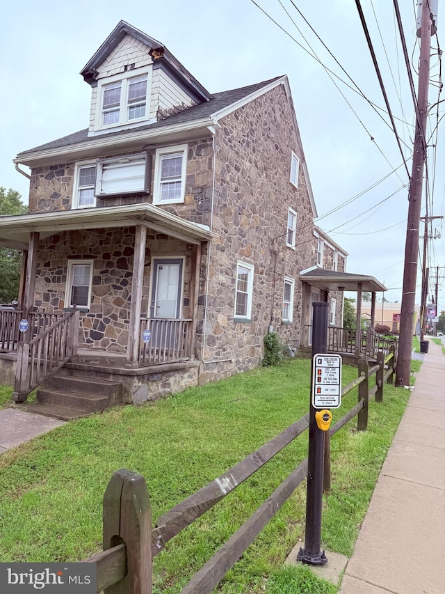 2410 Chichester Ave, Upper Chichester, PA 19061 - view of front of house with covered porch, stone siding, and a front yard