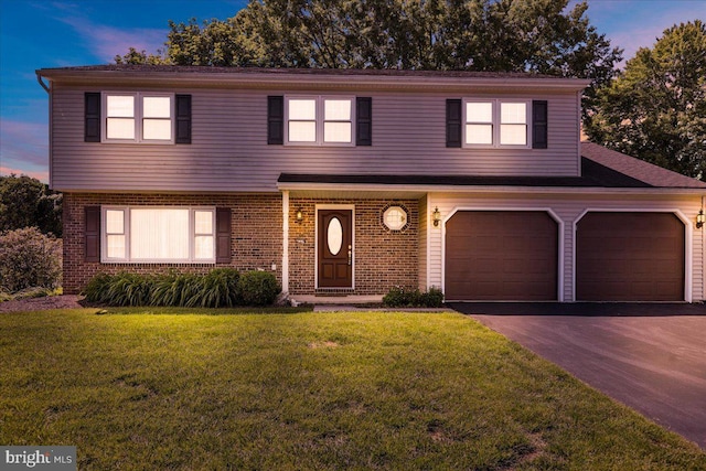 2110 Buckman Ave, Reading, PA 19610 - view of front facade with brick siding, asphalt driveway, a lawn, and a garage