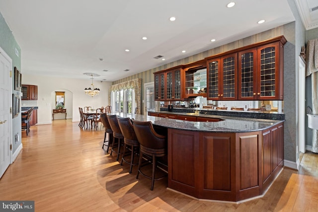 77 Lionheart Ter, Falling Waters, WV 25419 - indoor wet bar featuring light wood finished floors, recessed lighting, arched walkways, a chandelier, and decorative light fixtures
