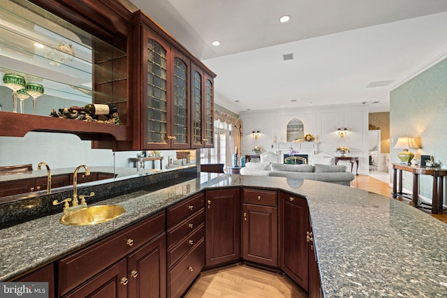 77 Lionheart Ter, Falling Waters, WV 25419 - kitchen featuring ornamental molding, dark stone countertops, open floor plan, glass insert cabinets, and light wood-type flooring