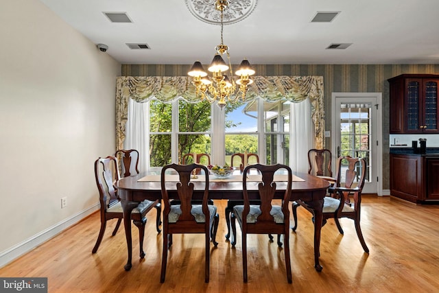 77 Lionheart Ter, Falling Waters, WV 25419 - dining room with a chandelier, wallpapered walls, and light wood-type flooring
