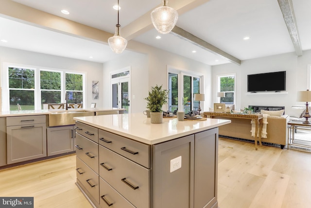 5809 2nd St S, Arlington, VA 22204 - kitchen featuring gray cabinets, beamed ceiling, light wood finished floors, a kitchen island, and healthy amount of natural light