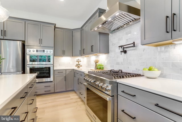 5809 2nd St S, Arlington, VA 22204 - kitchen with stainless steel appliances, gray cabinetry, wall chimney range hood, and light countertops