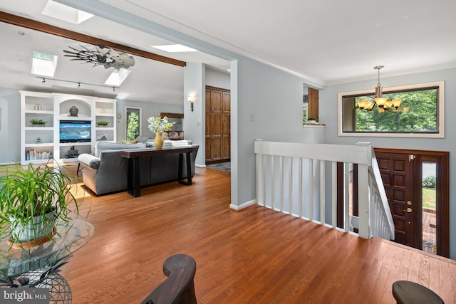 2404 Sugarberry Ct, Reston, VA 20191 - foyer featuring a skylight, a chandelier, light wood finished floors, ornamental molding, and baseboards