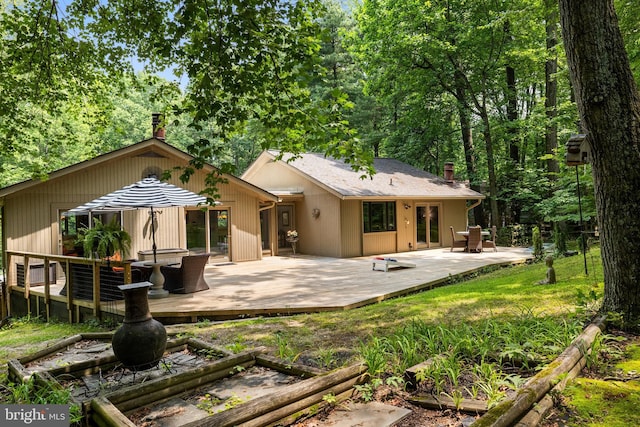 2404 Sugarberry Ct, Reston, VA 20191 - rear view of house with a chimney, a wooden deck, and a vegetable garden