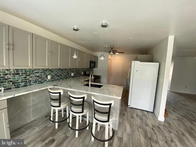 114 Mohican Ln, Tuckerton, NJ 08087 - kitchen with freestanding refrigerator, gray cabinets, a sink, wood finished floors, and tasteful backsplash
